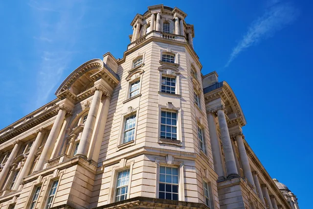 Low angle view of the iconic Port of Liverpool Building with blue sky. Five checks behind appointment setting agencies agency reviews